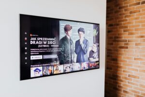 Smart TV displaying streaming content in modern living room setting with exposed brick wall.